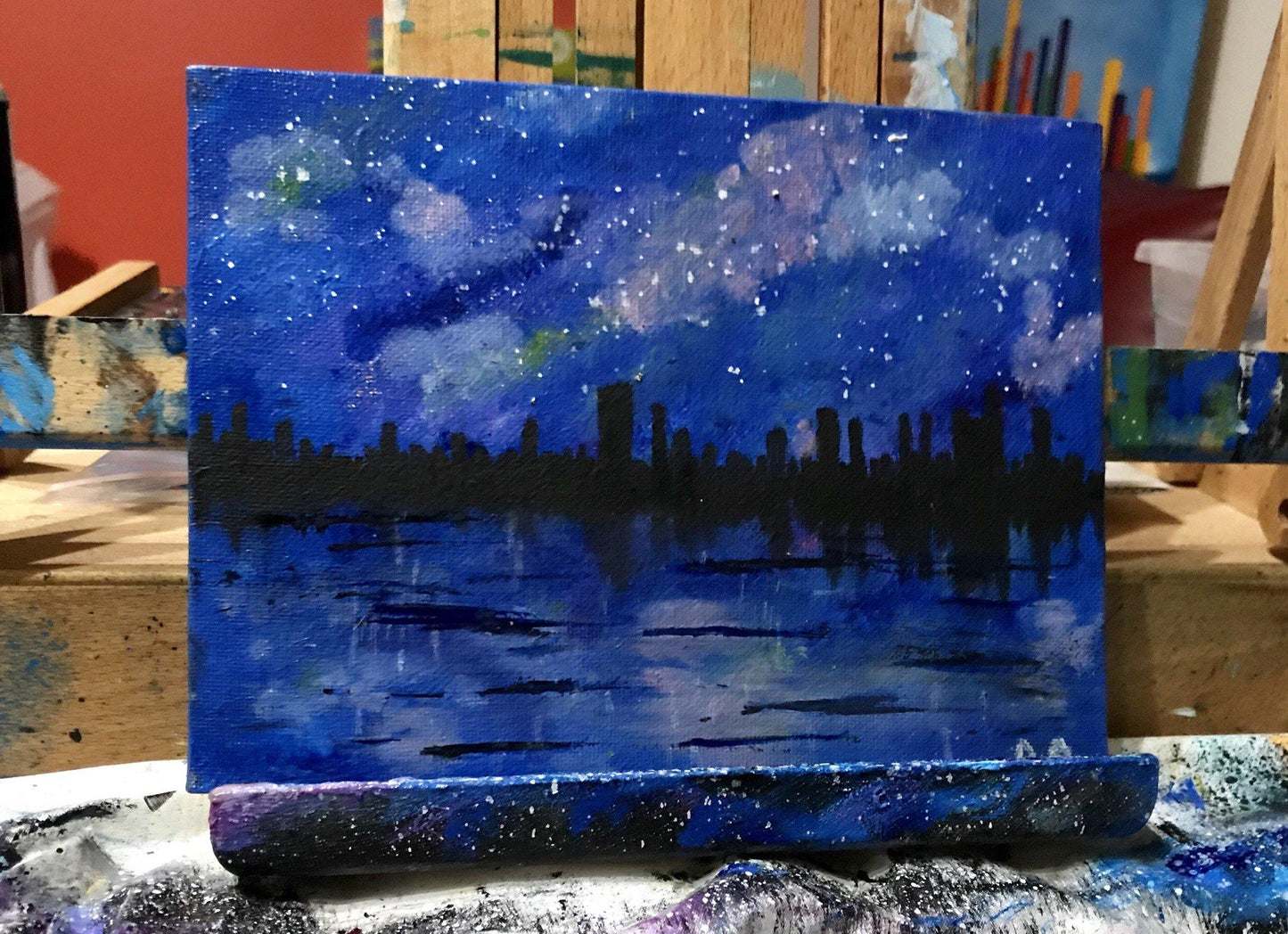 Original oil paintings of city skyline over a lake/river on a starry night
